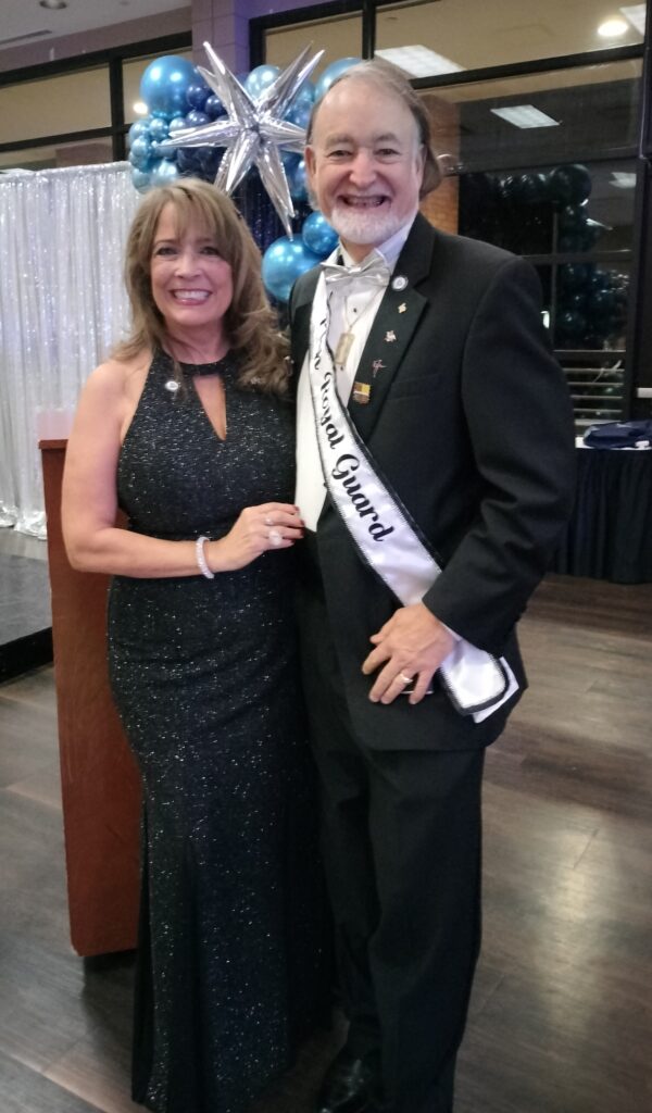 Two people standing and smiling.