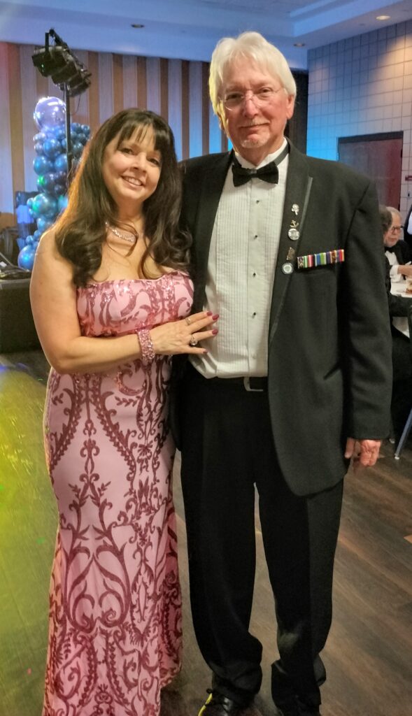 Two people standing and smiling.