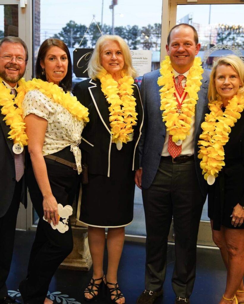 Five people standing next to each other and smiling.