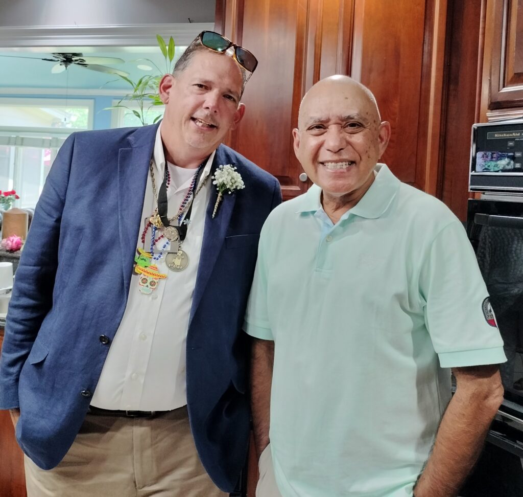 Two people standing and smiling.